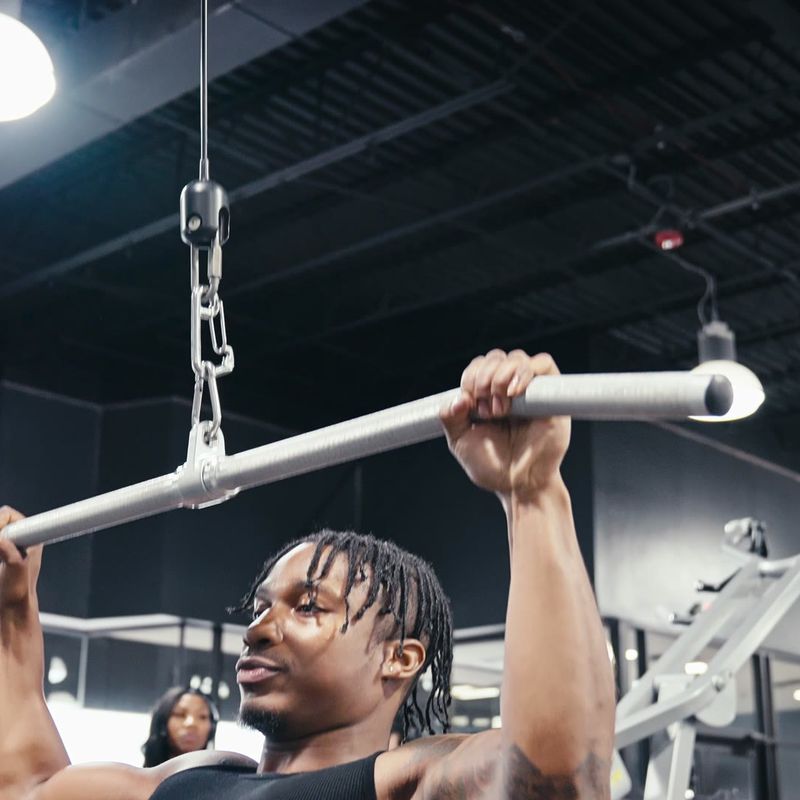 Damone gripping a cable bar overhead between sets